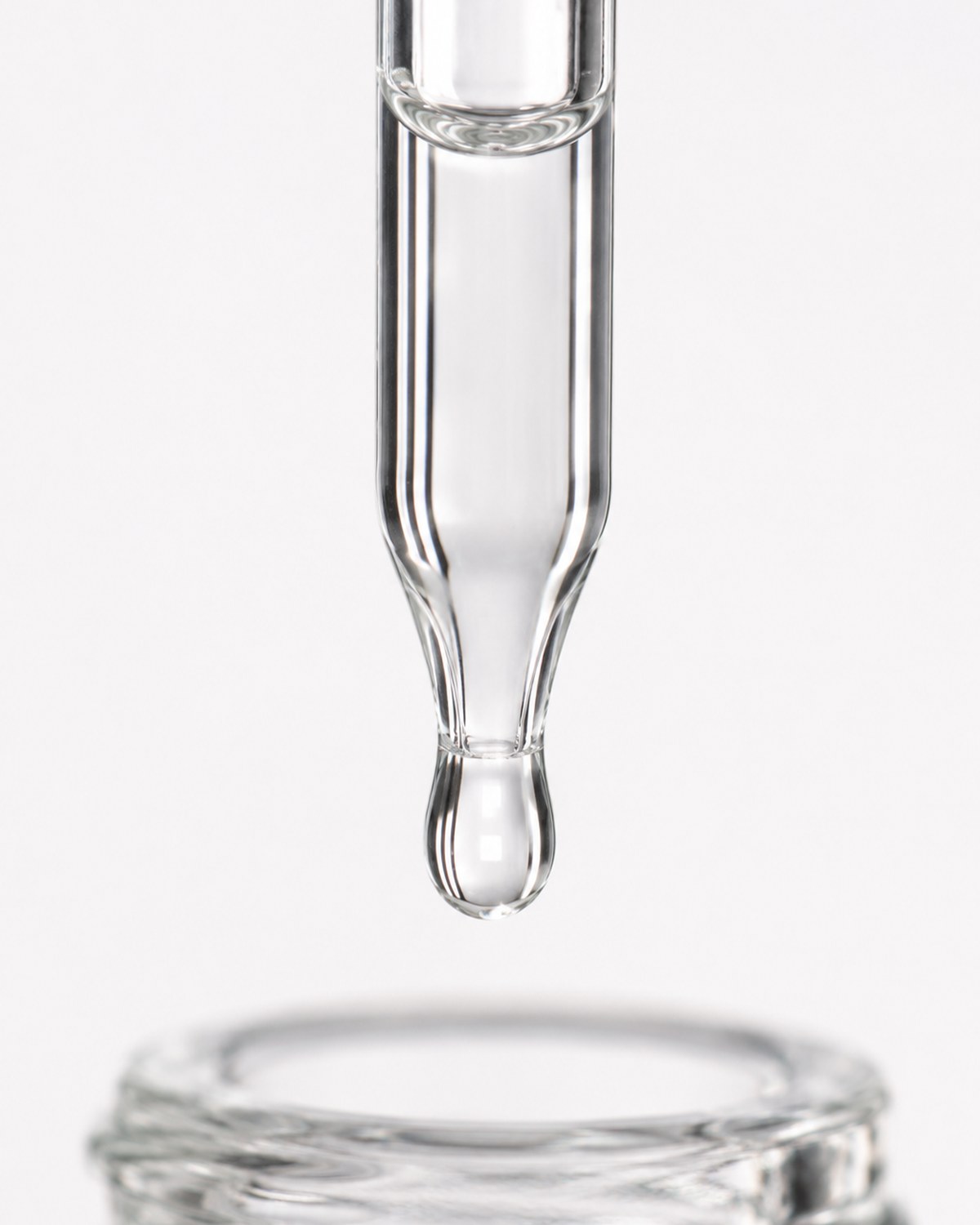 Macro — pipette wall, suspended droplet and bottle rim